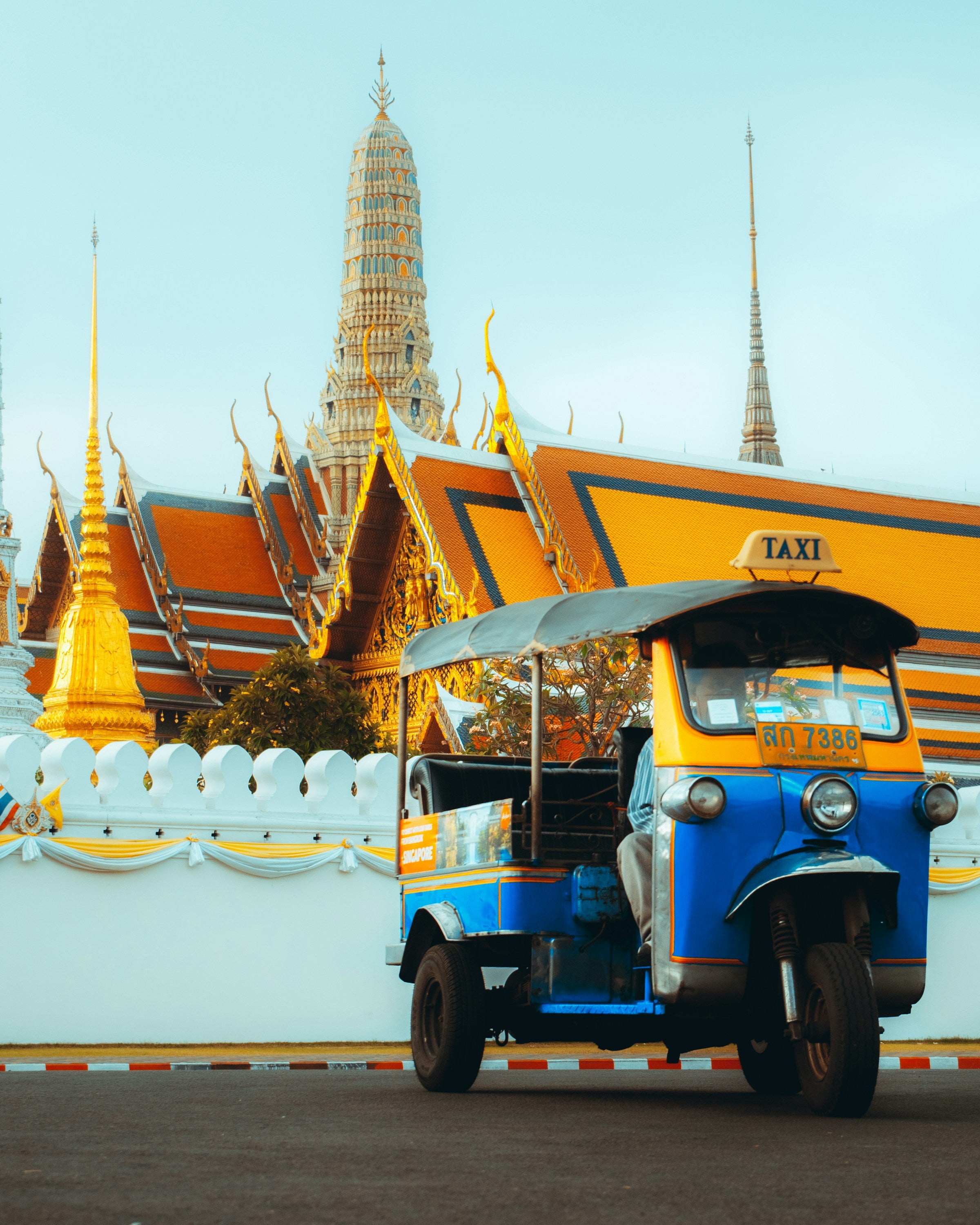 a tuk tuk parked in front of bangkok emerald temple